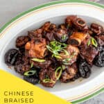 Close-up of tender Chinese braised spareribs with prunes (酸梅排骨) in a rich, glossy sauce, garnished with green onions, served in a white ceramic dish.