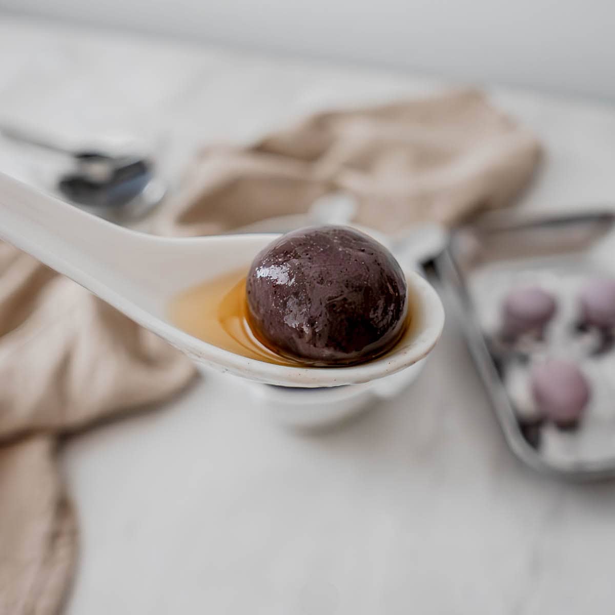 Black sesame tang yuan glutinous rice balls in ceramic bowls with warm ginger broth for Mid-Autumn Festival