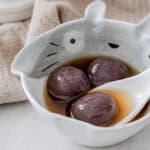 Black sesame tang yuan glutinous rice balls in ceramic bowls with warm ginger broth for Mid-Autumn Festival