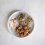 close up of Dried chrysanthemum flowers, honeysuckle buds, and licorice root ingredients for traditional Chinese cooling tea recipe