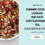 Cooling summer longan date tea in glass teacup with chrysanthemum flowers and goji berries on wooden table