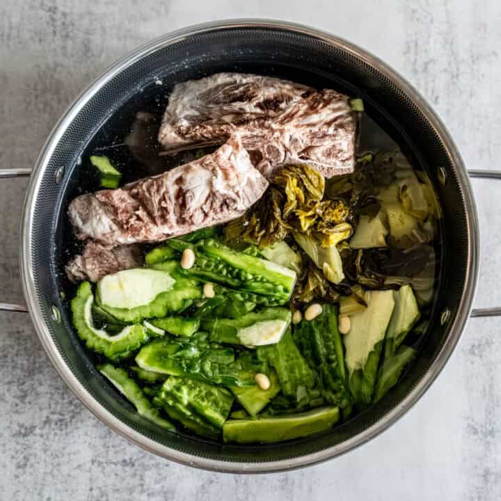 Discover this authentic bitter melon soup recipe with pork ribs and pickled greens. Traditional Chinese medicine cooling soup perfect for summer heat. Ready in 3 hours!