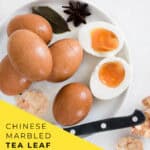 Soft boiled Chinese tea leaf eggs 茶葉蛋 sliced in half showing a marbled brown and white shell pattern and a jammy amber yolk, with text overlay reading soft boiled Chinese tea leaf eggs.